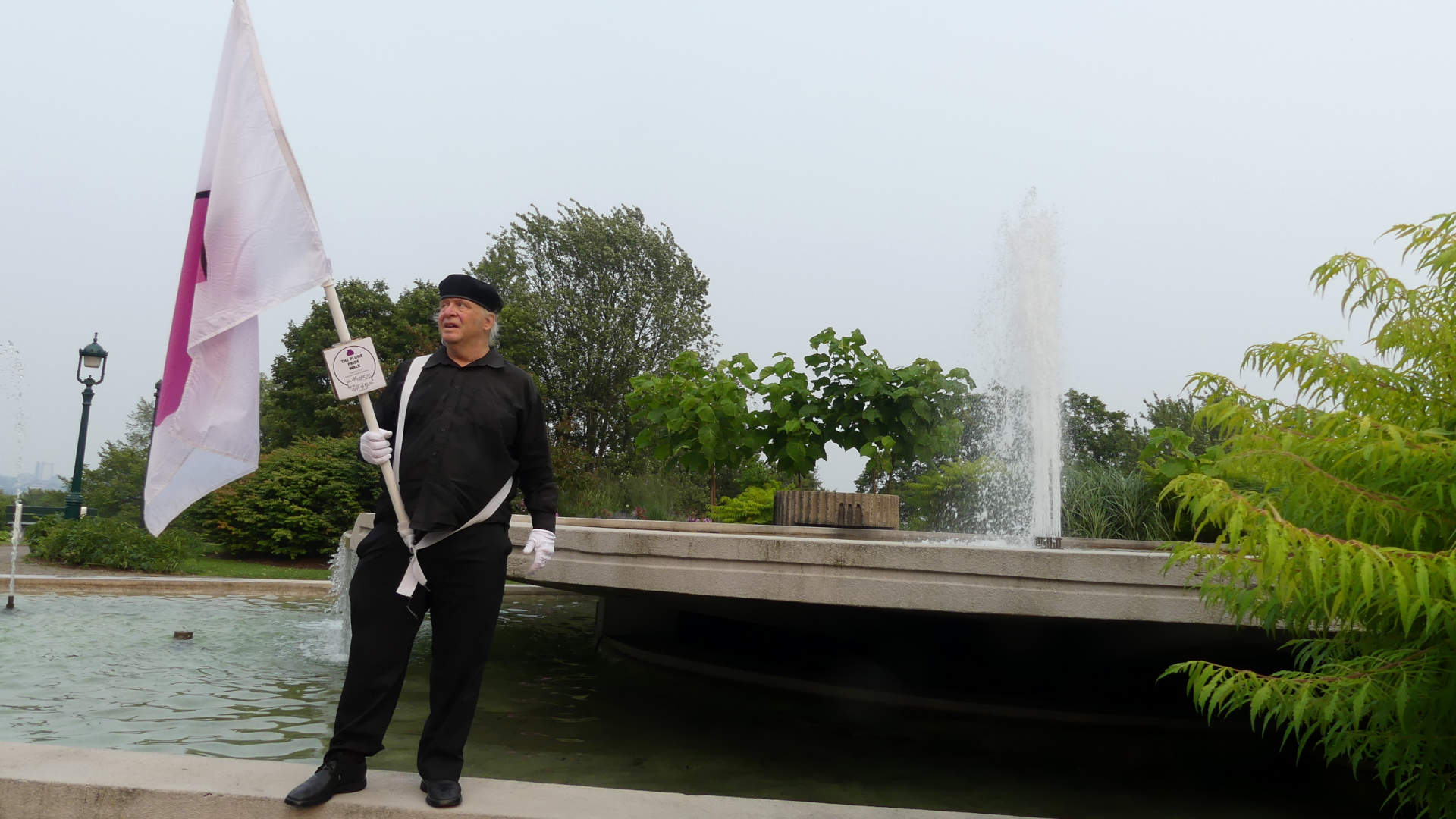 Je marche avec mon drapeau de la fiert ronde devant la Fontaine du Centenaire