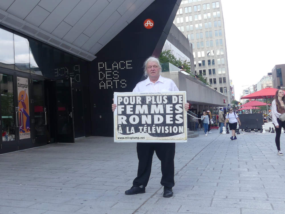 Jos Breton devant l'entre de Place des arts de Montral manifestant pour plus de femmes rondes  la tlvision au gala des prix gmeaux 2025.
