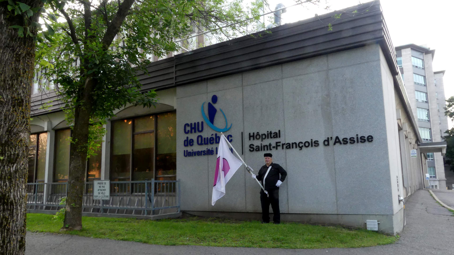 Je marche avec mon drapeau de la fiert� ronde devant l'H�pital St-Fran�ois D'Assise